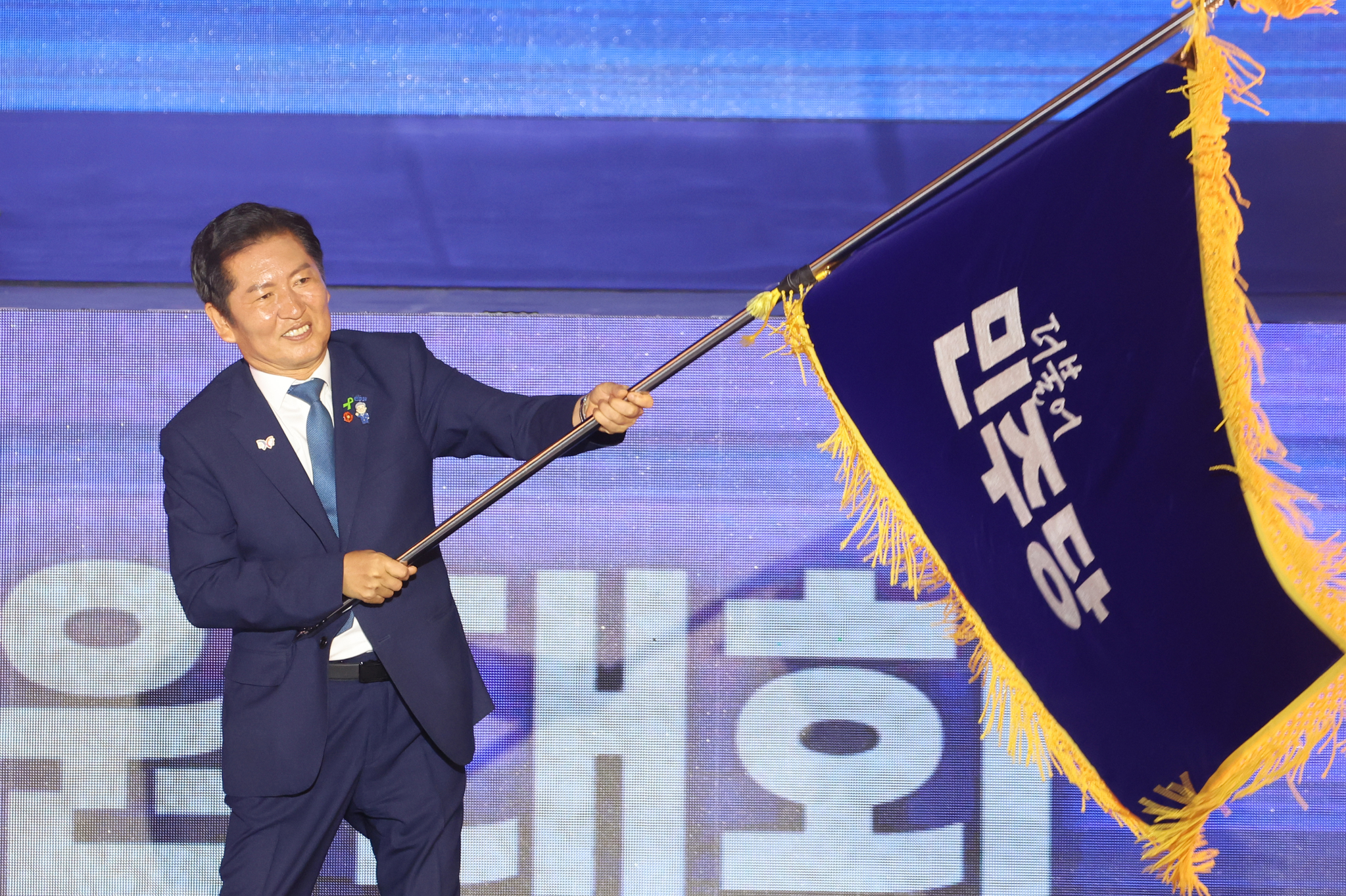 Newly-elected Democratic Party leader Jung Chung-rae waves the party flag during the party’s national convention at Kintex in Goyang, Gyeonggi on Aug. 2.  [YONHAP] 