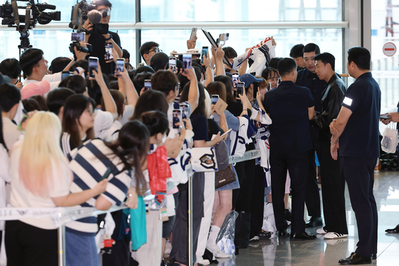 Son Heung-min, far right, signs an autograph at Incheon International Airport in Incheon on Aug. 5. [NEWS1] 