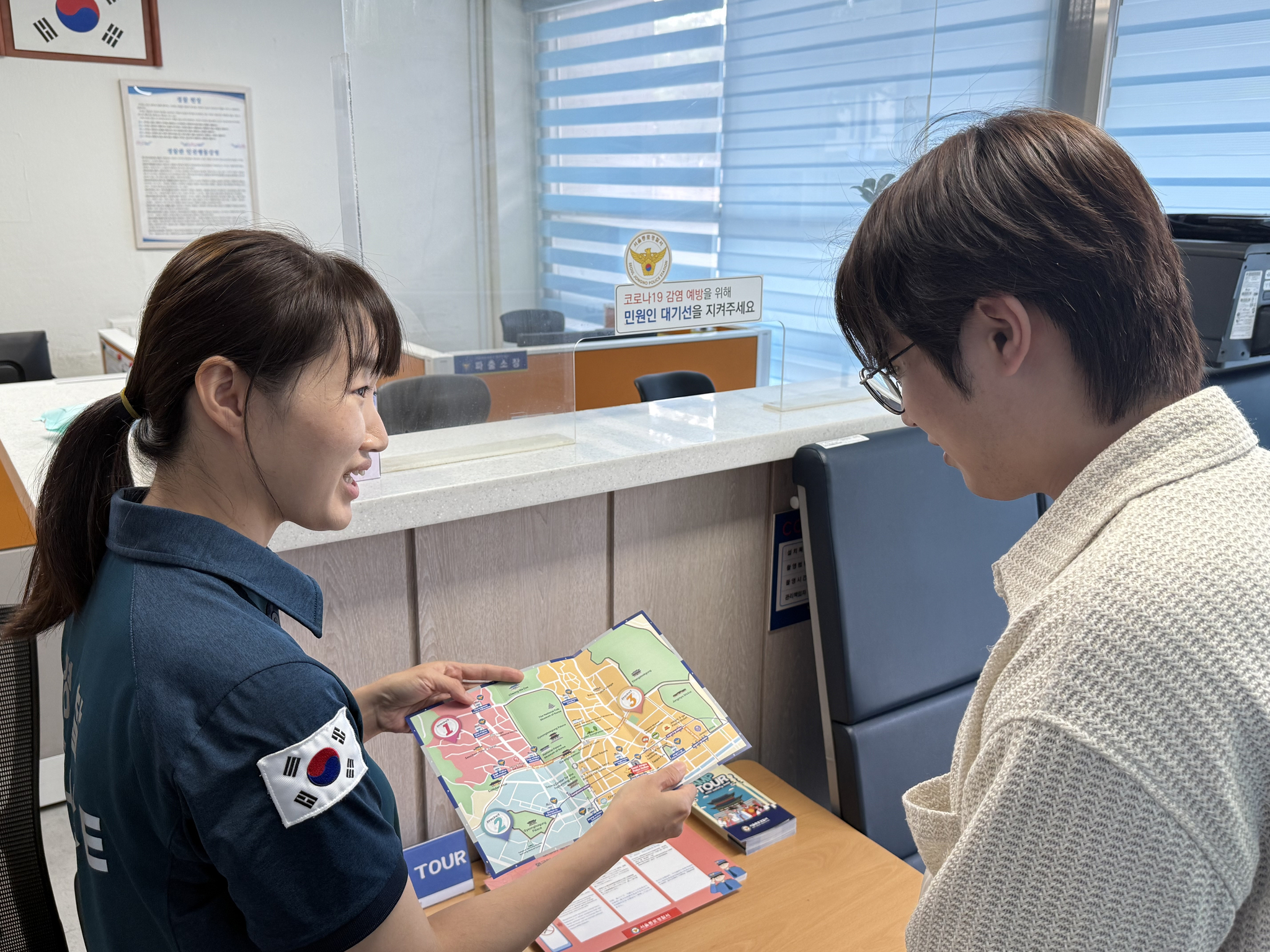 A police officer, left, explains the content of a pamphlet to reporter Chutian Shi as part of Jongno Police Station's recent initiative to prevent crimes. [YOON SEUNG-JIN]
