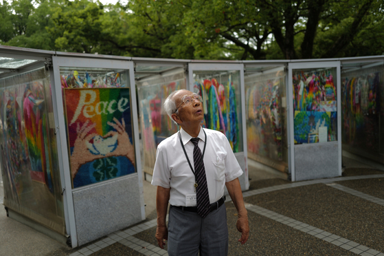 Kunihio Iida, atomic bomb survivor and volunteer guide who speaks in English to foreign visitors, looks at the sky in front of the Children's Peace Monument, where people offer paper cranes to honor the victims of the 1945 atomic bomb in Hiroshima, Japan, on July 9. [AP/YONHAP]