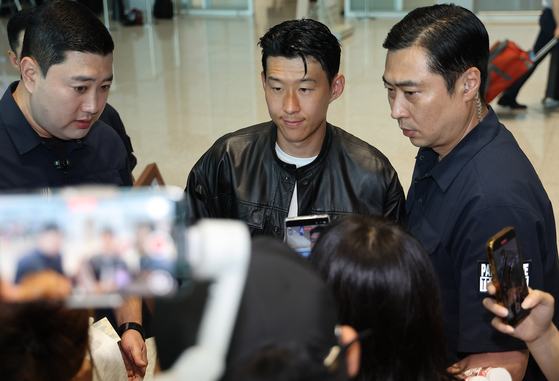 Son Heung-min, center, looks on at Incheon International Airport in Incheon on Aug. 5. [YONHAP]