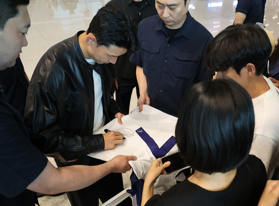 Son Heung-min signs an autograph at Incheon International Airport in Incheon on Aug. 5. [YONHAP] 
