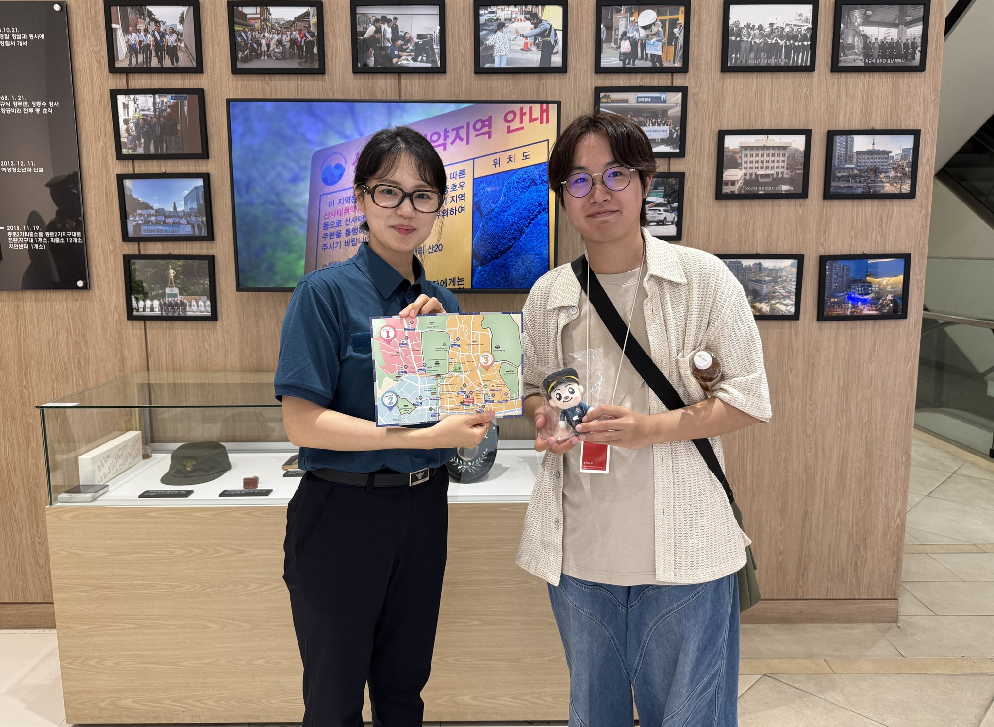 A police officer, left, and reporter Chutian Shi pose for a photo holding the prize for completing the mission. [YOON SEUNG-JIN]
