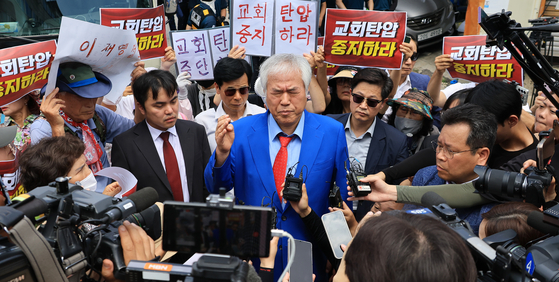 Far-right pastor Jeon Kwang-hoon of the Sarang Jeil Church speaks in front of his church in Seongbuk District, central Seoul, during a police raid on Aug. 5. [YONHAP]