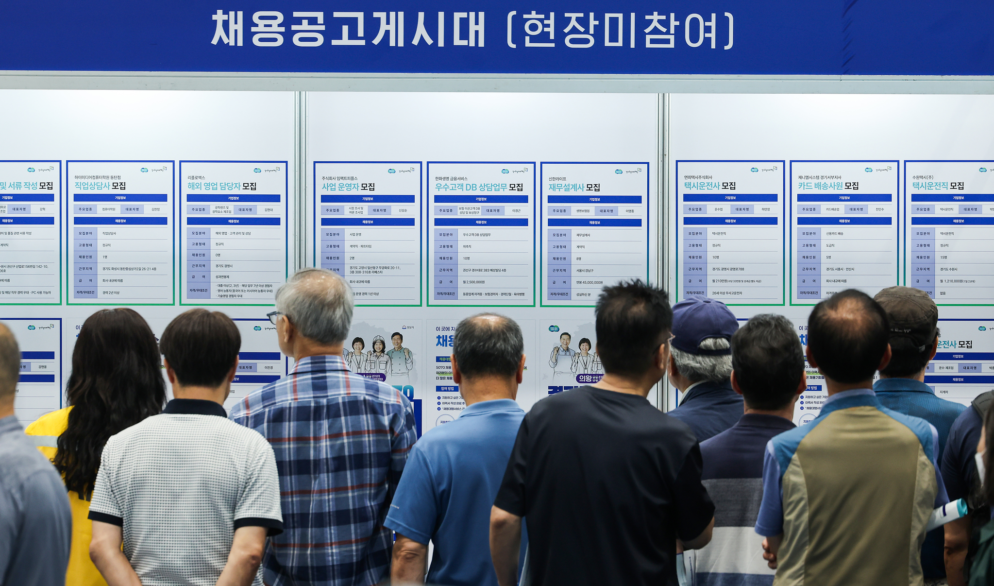 Job seekers look at notices posted at a job fair in Suwon, Gyeonggi, on July 9. [WOO SANG-JO]