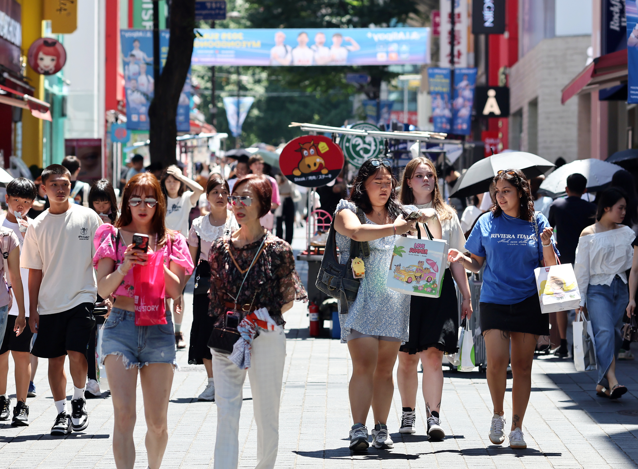Visitors walk around Myeong-dong, a shopping district in central Seoul, on July 27. [YONHAP] 