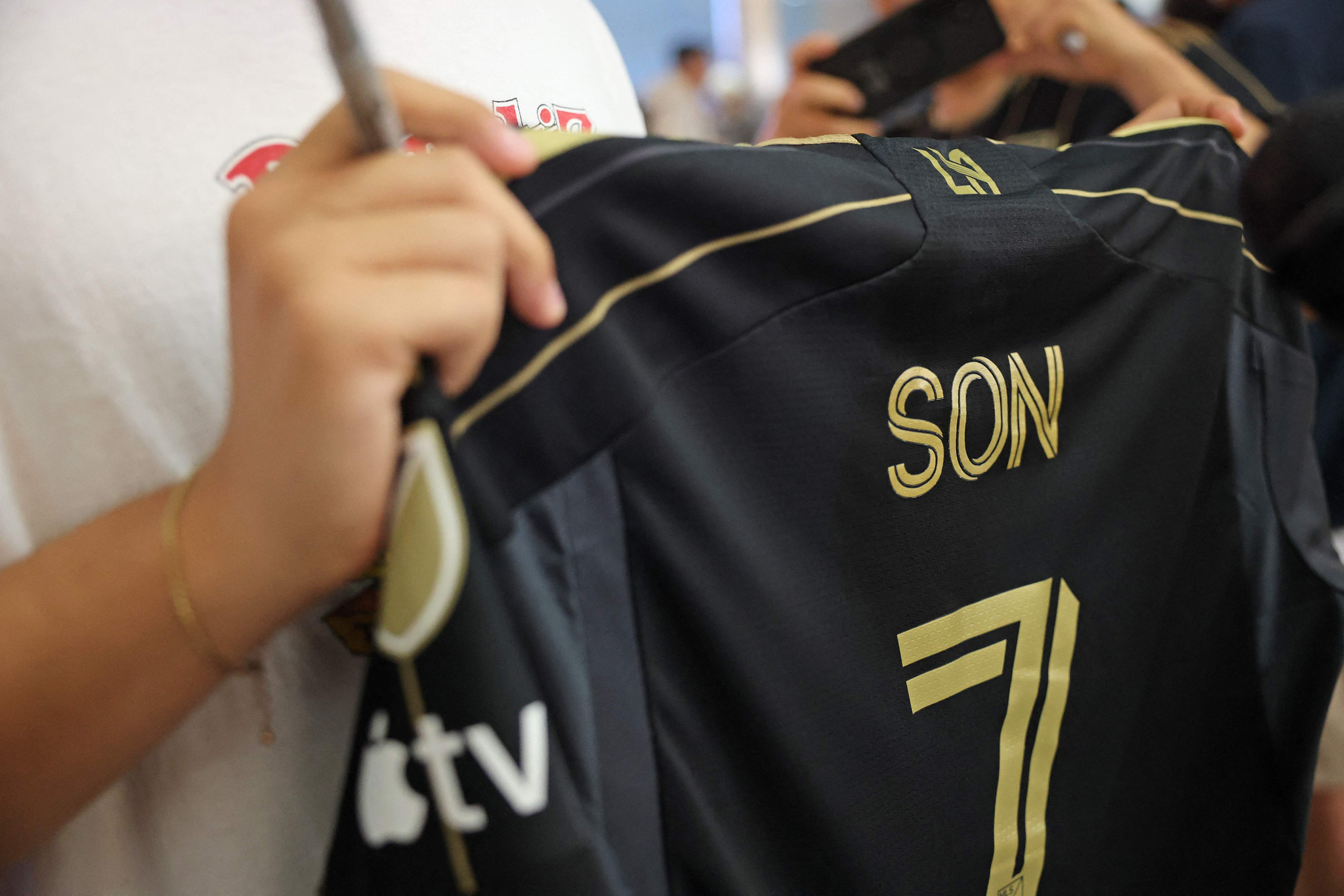 A Son Heung-min fan holds an LAFC shirt with Son's name and number on it as he waits for his arrival at Los Angeles International Airport in Los Angeles on Aug. 5. The shirt is not officialy available on the MLS Store, but fans can customize shirts with any name or number of their choosing.  [AFP/YONHAP]