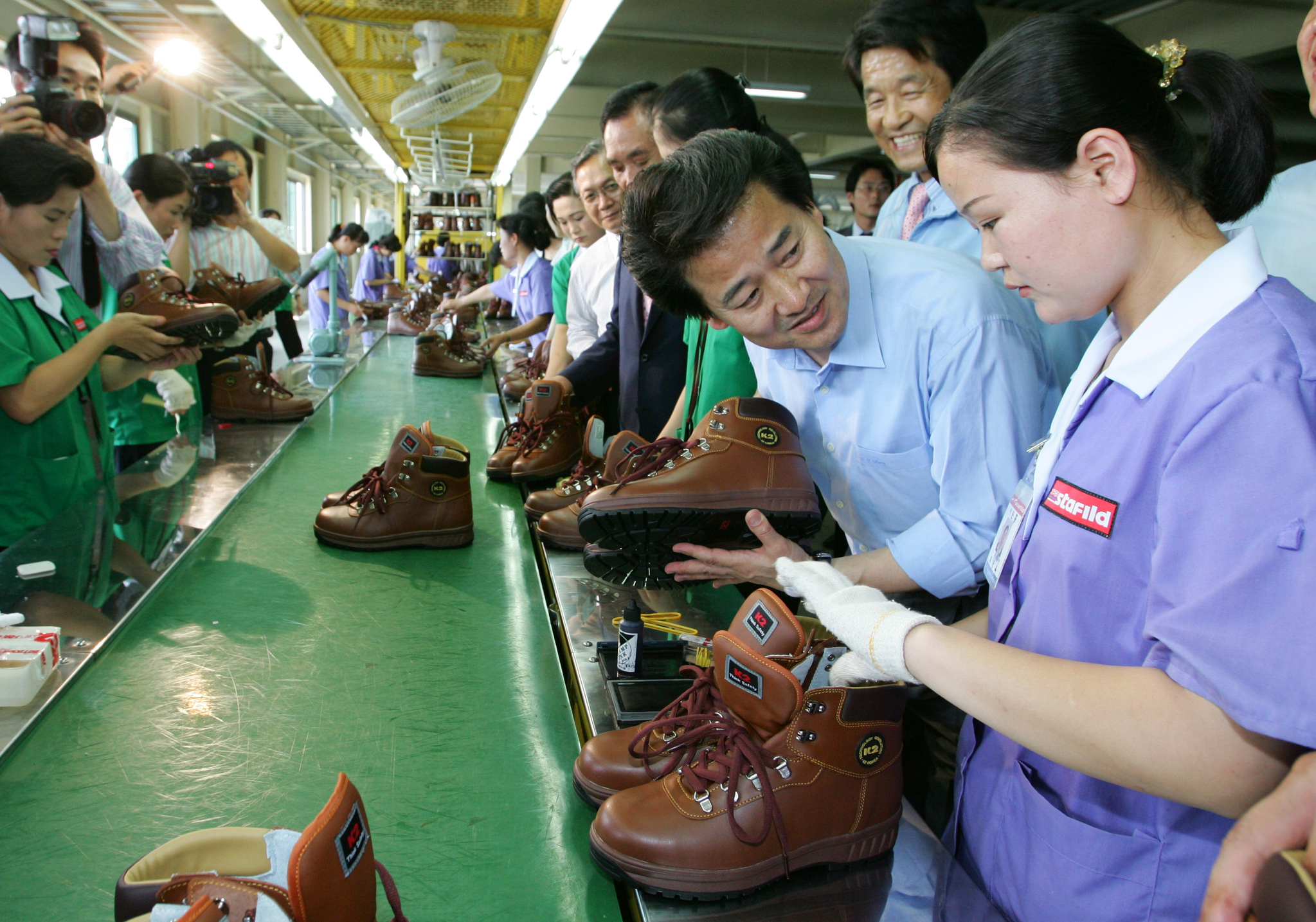 Unification Minister Chung Dong-young, second from right, speaks with a North Korean worker during a visit to a South Korean shoe manufacturer inside the Kaesong Industrial Complex on July 20, 2007. [JOINT PRESS CORPS]