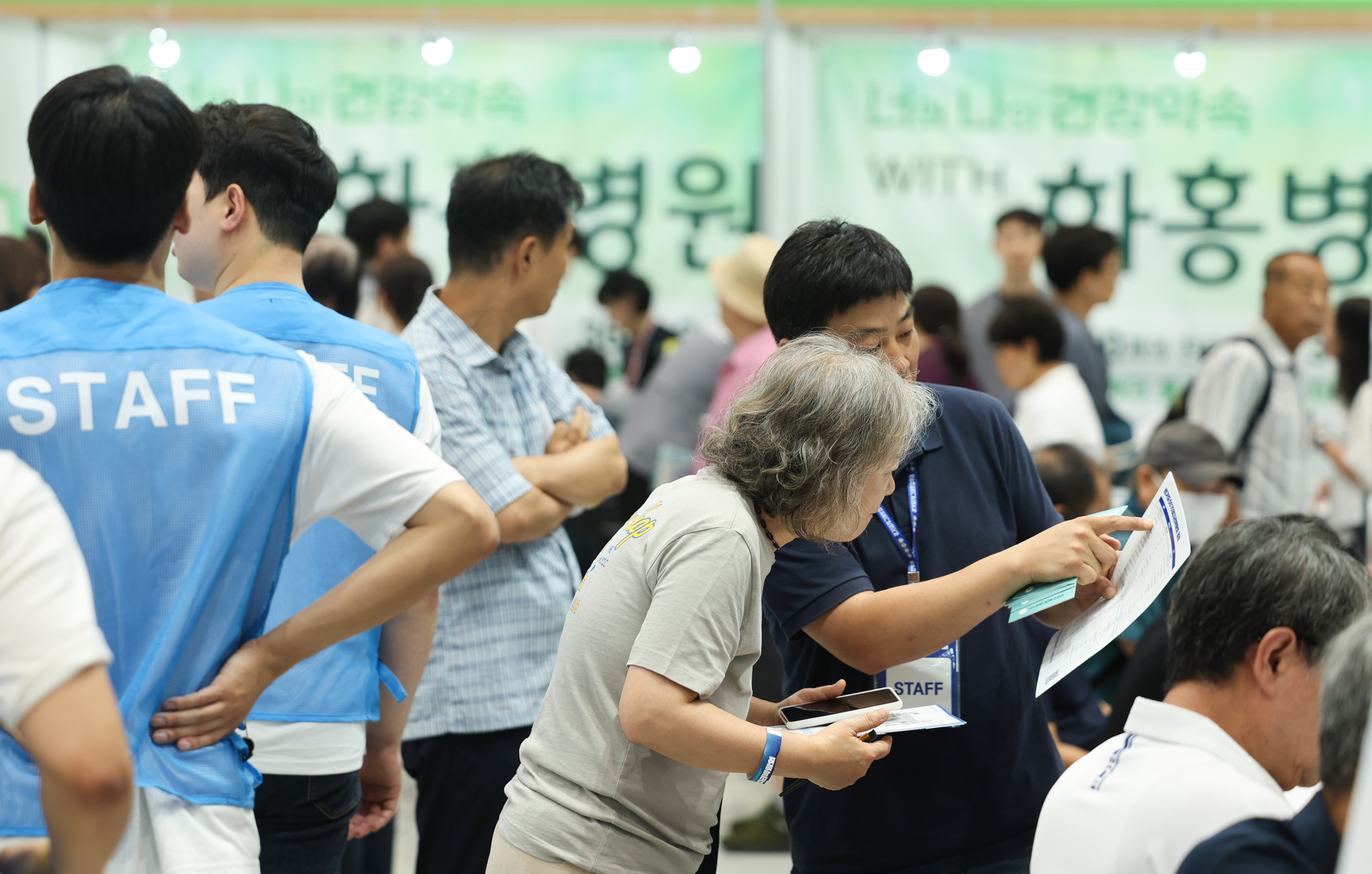 Job seekers look at notices posted at a job fair in Suwon, Gyeonggi, on July 9. [WOO SANG-JO]