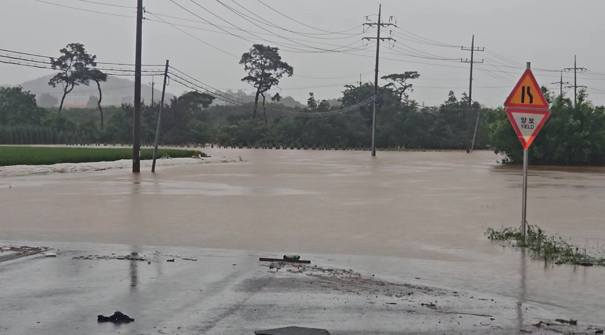Cheongji Stream overflows in Seosan, South Chungcheong, flooding roads and nearby farmland on July 17. [YONHAP]