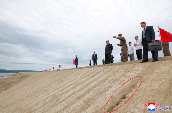 This photo, published by the Korean Central News Agency on Aug. 2, shows a crack in the newly built embankment on which North Korean leader Kim Jong-un stands during his visit to flood prevention construction sites in Sinuiju and Uiju, both in North Pyongan Province. [YONHAP]