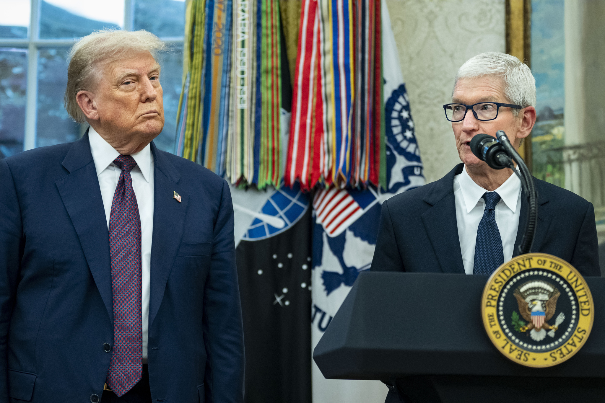 U.S. President Donald Trump looks on as Apple CEO Tim Cook announces an additional $100 billion in investment in the United States by Apple in the Oval Office of the White House in Washington on Aug. 6. [EPA/YONHAP]