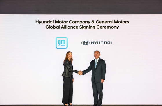 Hyundai Motor Group Executive Chair Euisun Chung, right, shakes hands with General Motors CEO Mary Barra after signing an agreement pledging cooperation in automobile development in New York in September 2024. [HYUNDAI MOTOR] 