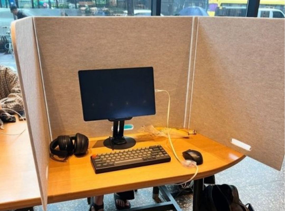 A tablet and keyboard behind a partition set up on a table in a Starbucks [SCREEN CATPURE]
