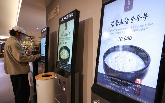 A person buys food items at a food court in a shopping mall in Seoul on March 27. [NEWS1]