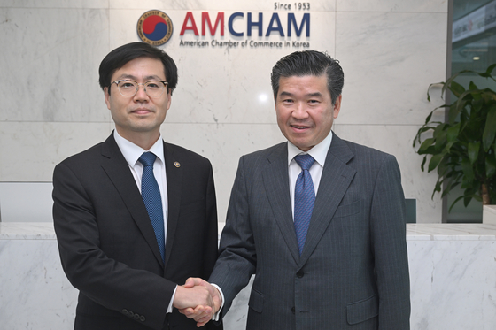 Trade Minister Yeo Han-koo, left, shakes hands with James Kim, CEO and chairman of the American Chamber of Commerce in Korea (Amcham), right, at Amcham's headquarters in western Seoul on Aug. 8. [NEWS1[