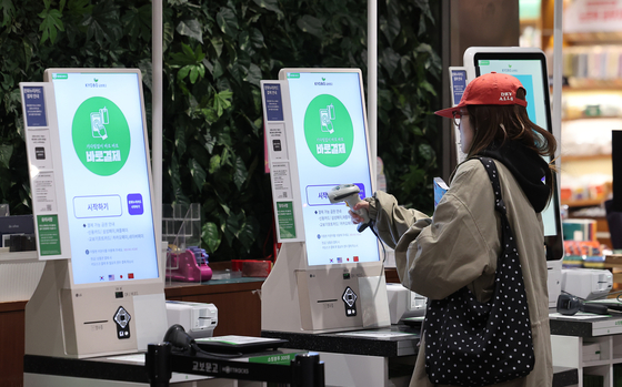 A shopper uses a kiosk to buy books at a large bookstore in downtown Seoul on March 27. [NEWS1]