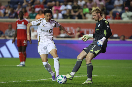 Los Angeles FC forward Son Heung-min, left, and Chicago Fire goalkeeper Chris Brady battle for control of the ball during an MLS match at SeatGeek Stadium in Bridgeview, Illinois on Aug. 9. [REUTERS/YONHAP]