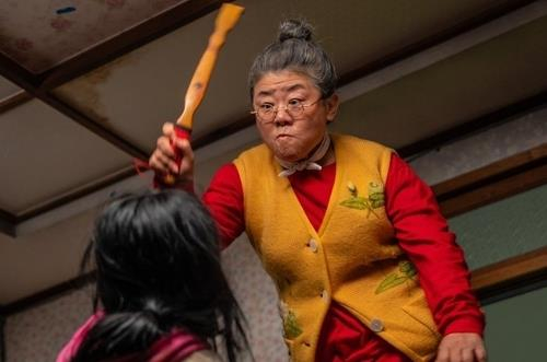 Bam-soon brandishes her back scratcher at her zombie granddaughter, Soo-ah, in this still from ″My Daughter is a Zombie,″ provided by NEW. [YONHAP] 
