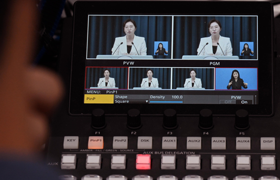 A sign language interpreter simultaneously relays spokesperson Kang Yu-jung’s press briefing at the Yongsan presidential office in central Seoul on Aug. 12. [JOINT PRESS CORPS] 