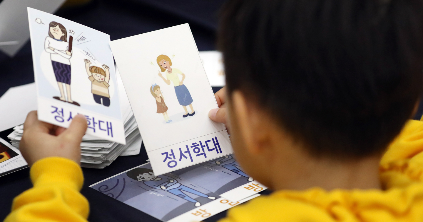 A child holds cards depicting child abuse at an event to prevent child abuse in Sejong in 2019. [NEWS1]