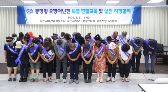 Vendors and officials from the Sokcho's squid market hold a resolution meeting at the Sokcho Fisheries Cooperative to apologize over recent allegations of unfriendly service on Aug. 8. [YONHAP]