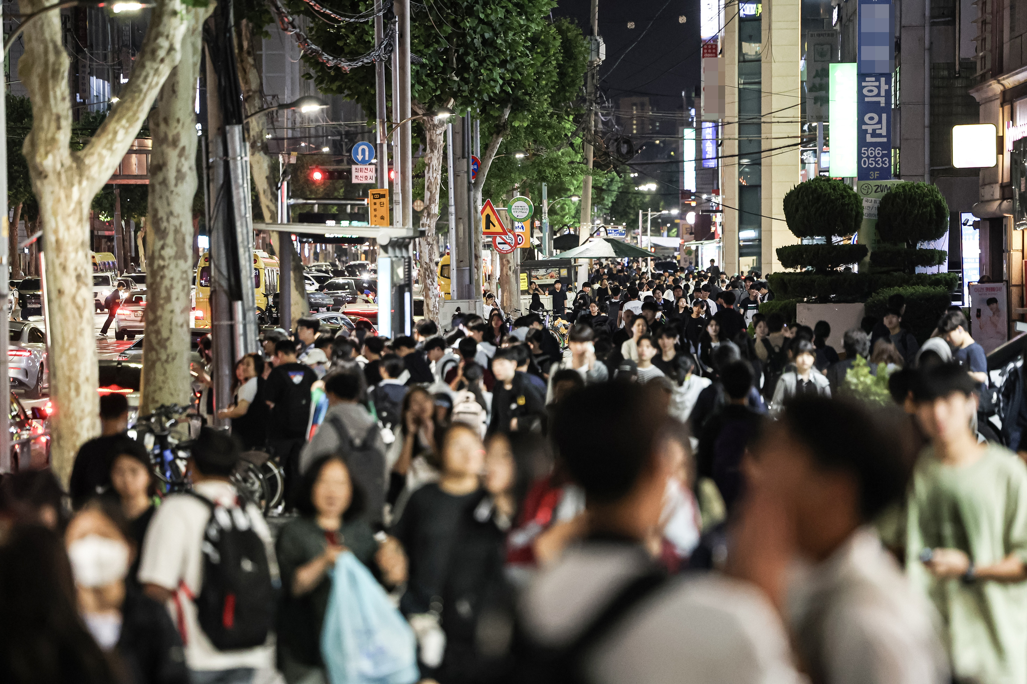 A view of Daechi-dong’s private academy district around 10 p.m. in June 2024. After official classes at cram schools and other test-prep institutes ended, crowds of students, parents, and vehicles filled the streets near the Eunma Apartment Intersection in Gangnam District, Seoul. [KIM KYUNG-ROK]