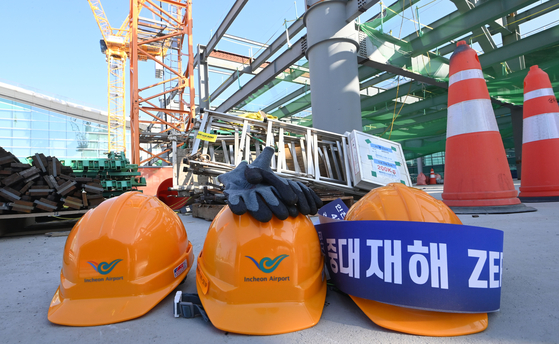 Safety helmets and gloves are laid out at a construction site. [NEWS1]