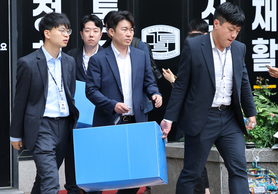 Members of Special Counsel Min Joong-ki’s team investigating various allegations involving former First Lady Kim Keon Hee carry boxes of seized items after completing a raid of Seohee Construction’s headquarters in southern Seoul on Aug. 11. [NEWS1]