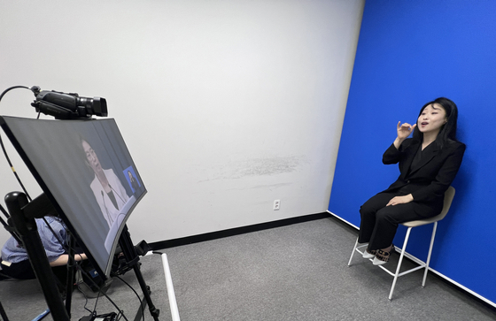 A sign language interpreter relays spokesperson Kang Yu-jung’s press briefing announcing President Lee Jae Myung's visit to the United States for a summit with U.S. President Donald Trump at the Yongsan presidential office in central Seoul on Aug. 12. [JOINT PRESS CORPS] 
