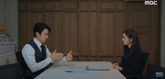 A scene from “When the Phone Rings” shows actor Chae Soo-bin, right, as a sign language interpreter who works for the presidential office teaching sign language to the presidential spokesperson, played by actor Yoo Yeon-seok. [SCREEN CAPTURE]