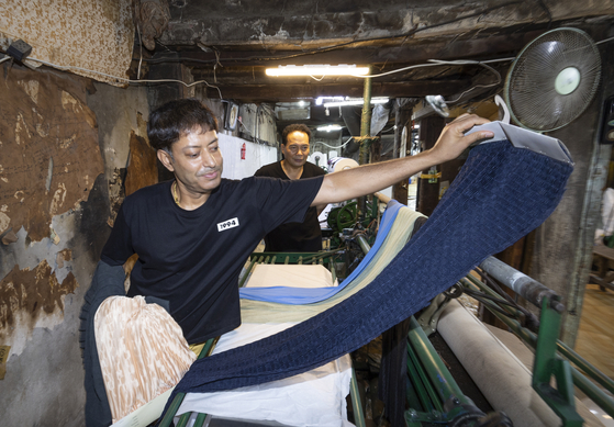 Bangladesh-born Kim Russell, who became a Korean citizen, shows off the materials he made at a factory in central Seoul. Behind him is his boss, Kim Bok-hwan. [KIM SANG-SEON]