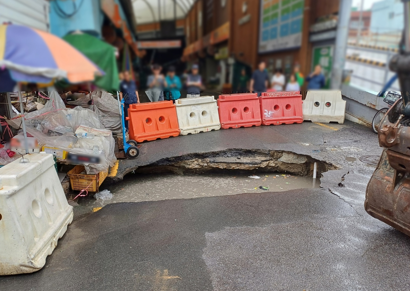 A large sinkhole measuring 5 meters (16 feet) long and 1 meter wide opens on a road in Sasang District, Busan, on Aug. 12. [YONHAP] 