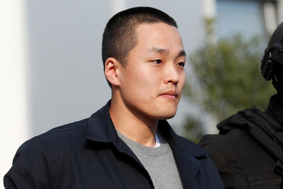 Police officers escort Terraform Labs co-founder Do Kwon after he served a sentence for document forgery, in Podgorica, Montenegro on March 23, 2024. [REUTERS/YONHAP]
