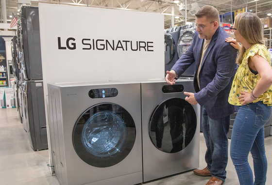 Customers look at an LG Signature washer and dryer on display at a Lowe’s store. [NEWS1] 