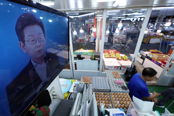 Merchants operate as the live broadcast of the State Affairs Planning Committee’s public report meeting airs at a traditional market in Seoul on Aug. 13. [NEWS1]