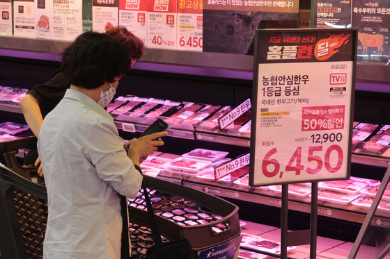 Shoppers look at meat on display at the Homeplus Gangseo branch in western Seoul on July 24. [YONHAP]