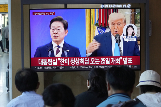 People watch the news announcing the date for Korean President Lee Jae Myung and U.S. President Donald Trump's first summit at Seoul Station in central Seoul on Aug. 12. [AP/YONHAP]