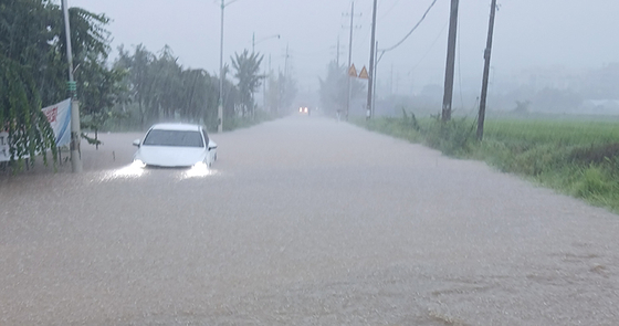 A car is submerged in a flooded road in the Daejang-dong area near Daegok Station in Goyang, Gyeonggi, after heavy rainfall on Aug. 13 in this photo provided by a reader. [JOONGANG ILBO]