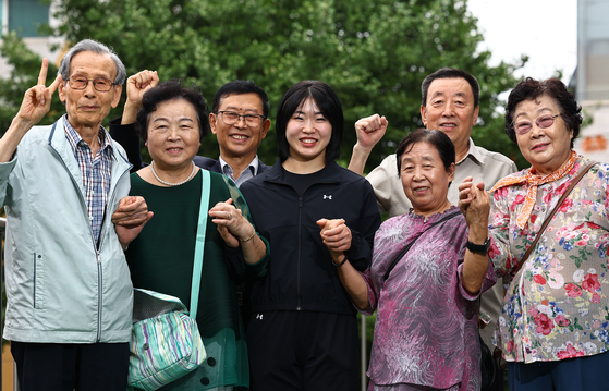 Hur Mi-mi, center, stands alongside descendants of independence activists at the entrance to the office of an association for such descendants in Mapo District, western Seoul, on Aug. 14. [KIM JONG-HO]