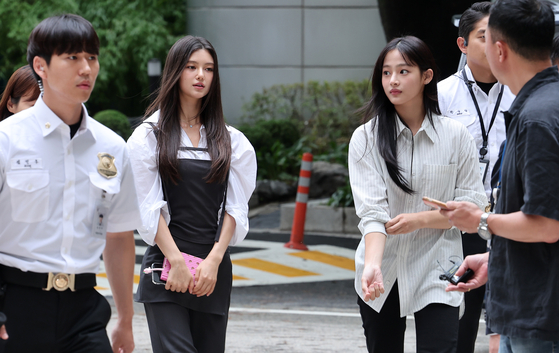 NewJeans member Danielle, center left, and Minji appear at Seoul Central District Court in southern Seoul on Aug. 14. [NEWS1] 