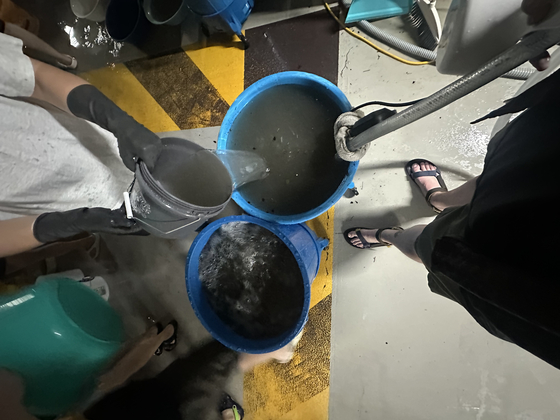 Residents finish cleaning up the basement of an apartment complex in western Gyeonggi.  [JIM BULLEY]