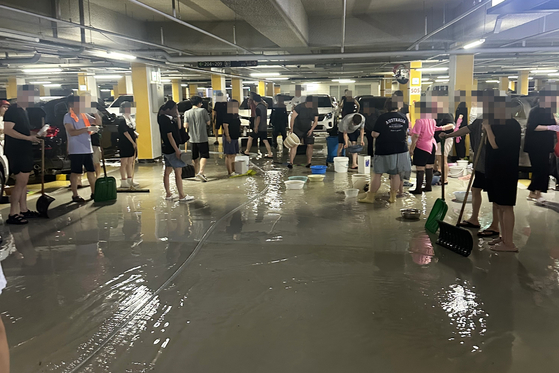 Residents finish cleaning up the basement of an apartment complex in western Gyeonggi.  [JIM BULLEY]