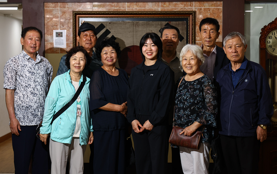 Huh Mi-mi, center, stands alongside descendants of independence activists in front of a Korean national flag at the entrance to an association for such descendants in Mapo District, western Seoul, on Aug. 14. [KIM JONG-HO]