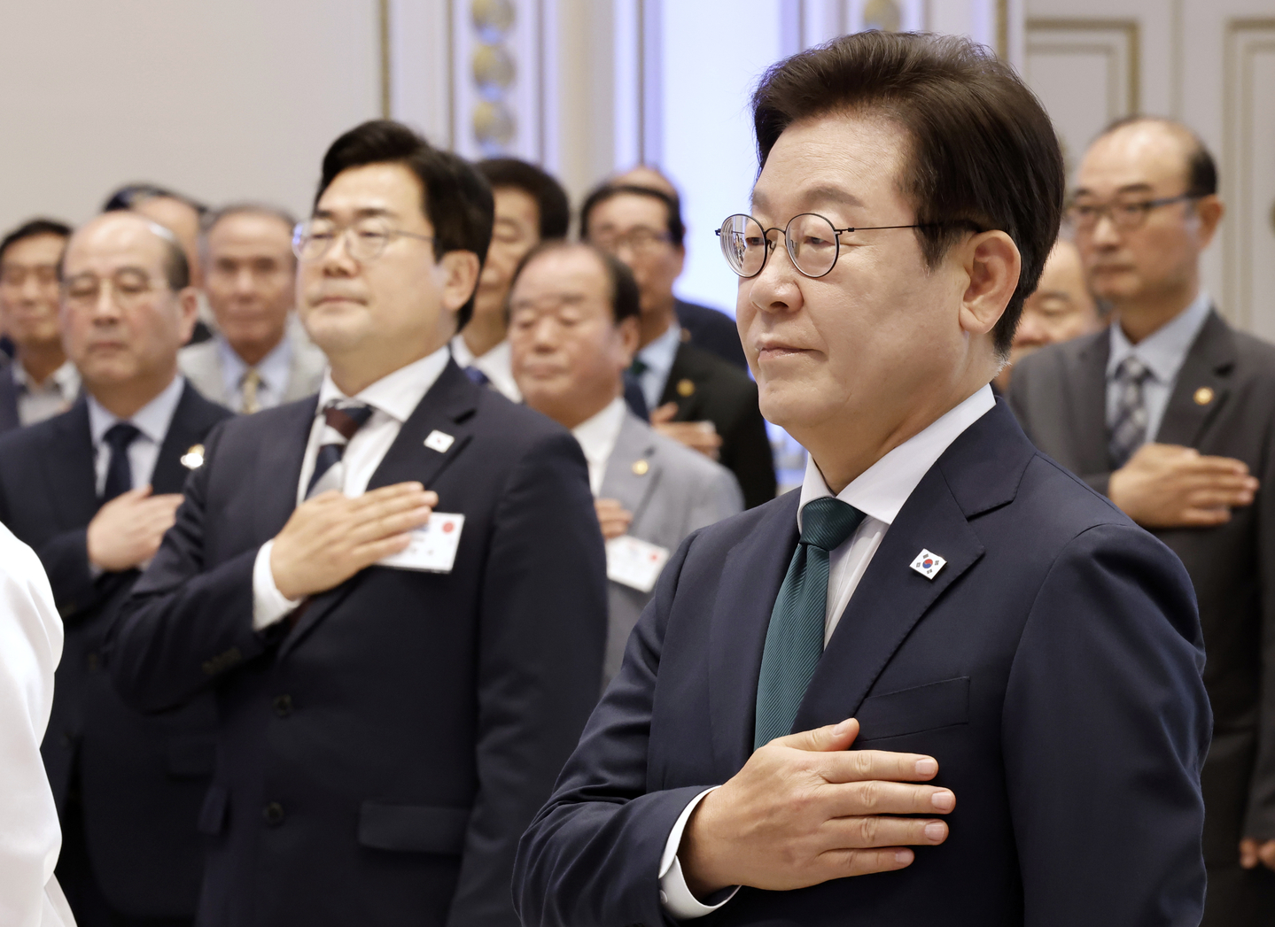 President Lee Jae Myung, right, salutes the national flag at an event commemorating the 80th anniversary of Liberation Day at the former presidential office, Cheong Wa Dae, in Seoul on Aug. 14. [JOINT PRESS CORPS]