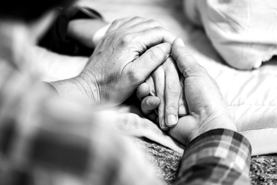 A husband holds the hand of his wife, who is terminally ill with cancer, at their home in Yongin, Gyeonggi, on March 27, 2023. [JOONGANG ILBO] 