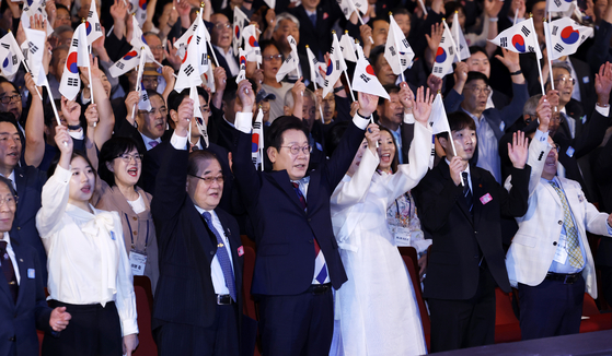 President Lee Jae Myung, center, waves the Korean flag during a ceremony marking the 80th Liberation Day at the Sejong Center for Performing Arts in Jongno District, central Seoul, on Aug. 15. [JOINT PRESS CORPS]
