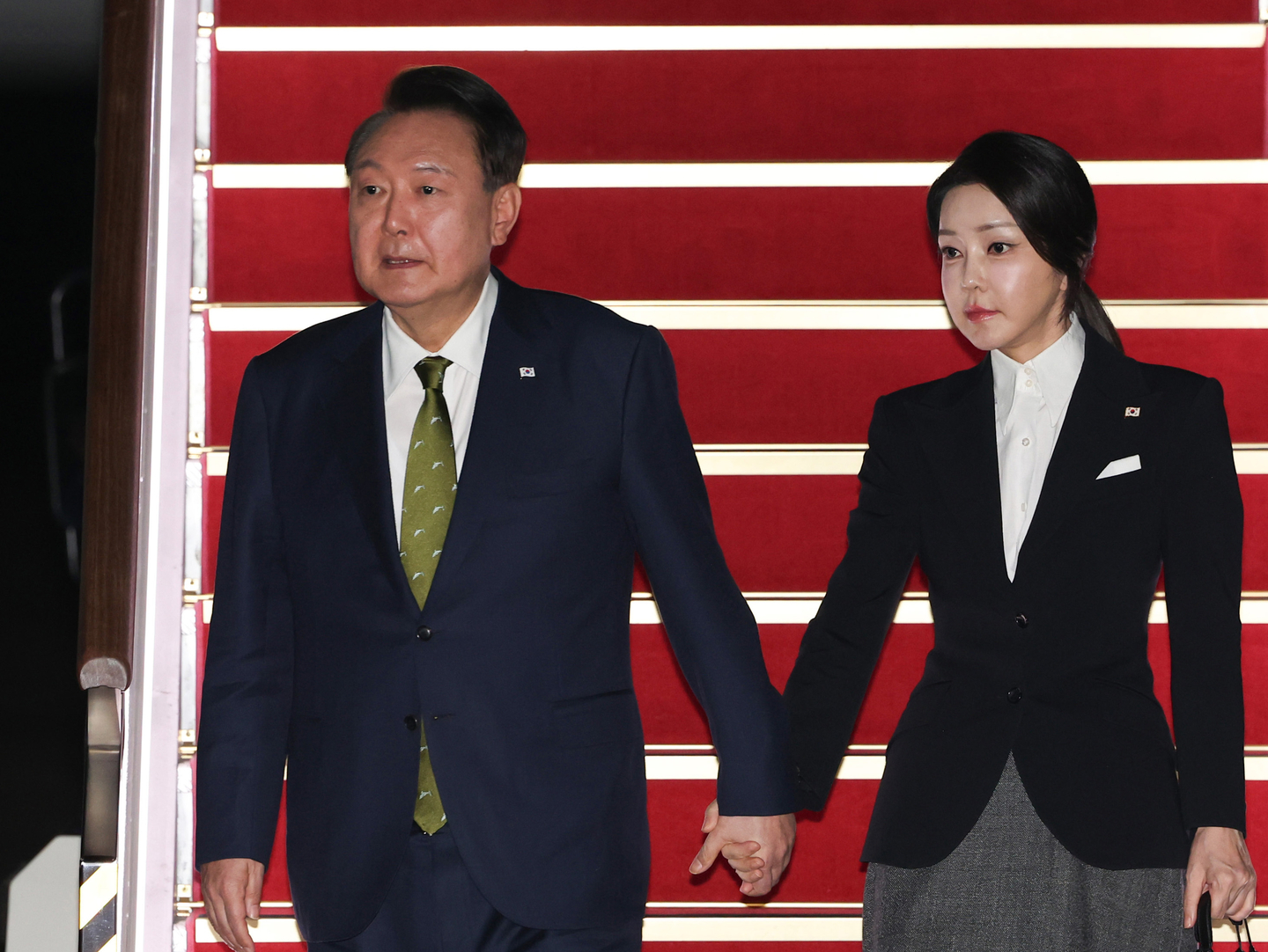 Former President Yoon Suk Yeol, left, and his wife, Kim Keon Hee, arrive at the Seoul Air Base in Seongnam, Gyeonggi, after their visit to the Philippines and Singapore on Oct. 11. 2024. [YONHAP]