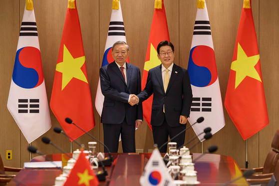 President Lee Jae Myung, right, and General Secretary To Lam of the Communist Party of Vietnam, left, shake hands during a summit at the presidential office in Yongsan, central Seoul on Aug. 11. [PRESIDENTIAL OFFICE]