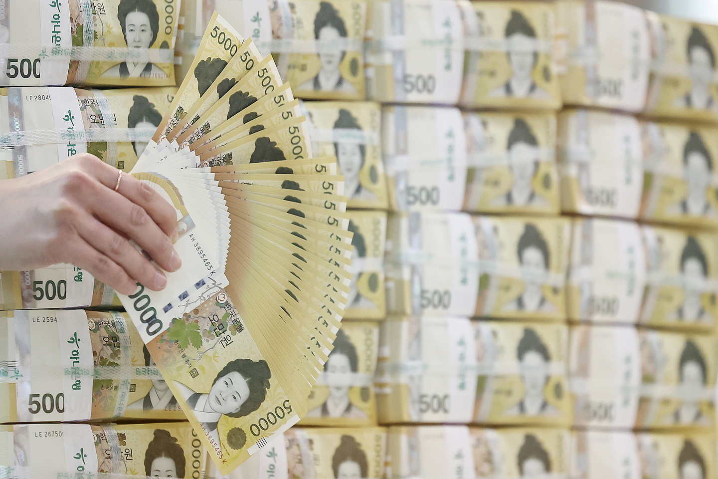 A Hana Bank official holds up 50,000 won ($36) bills at the bank's office in Jung District, central Seoul, on Feb. 19. [NEWS1]